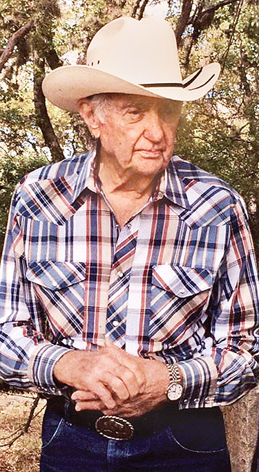 A photo shows an older man wearing a long-sleeved plaid shirt with pearl snaps and a cowboy hat.